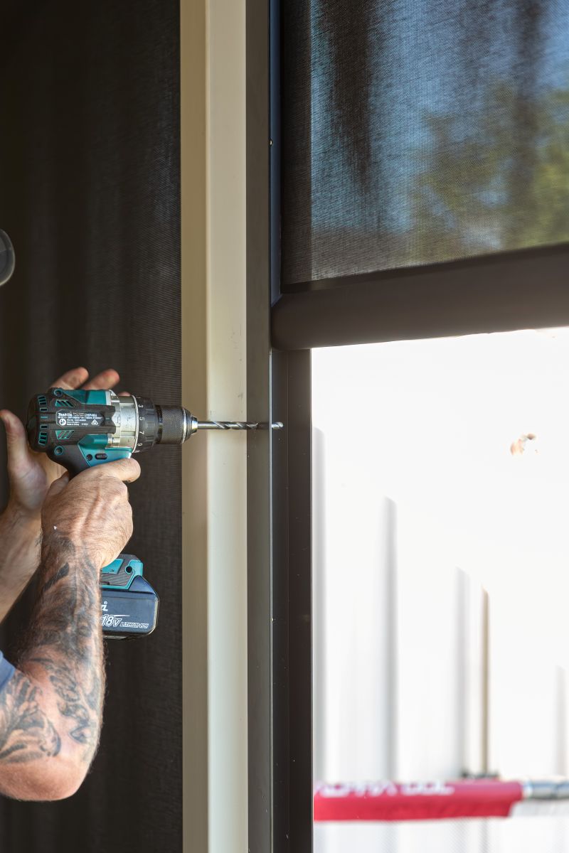 Tradie drilling a Channel blind into a wall